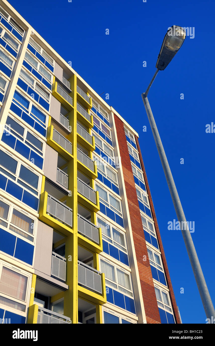 Vibrantly coloured refurbished 1960`s residential council flats with a deep blue sky and a lamp post viewed upwards Stock Photo